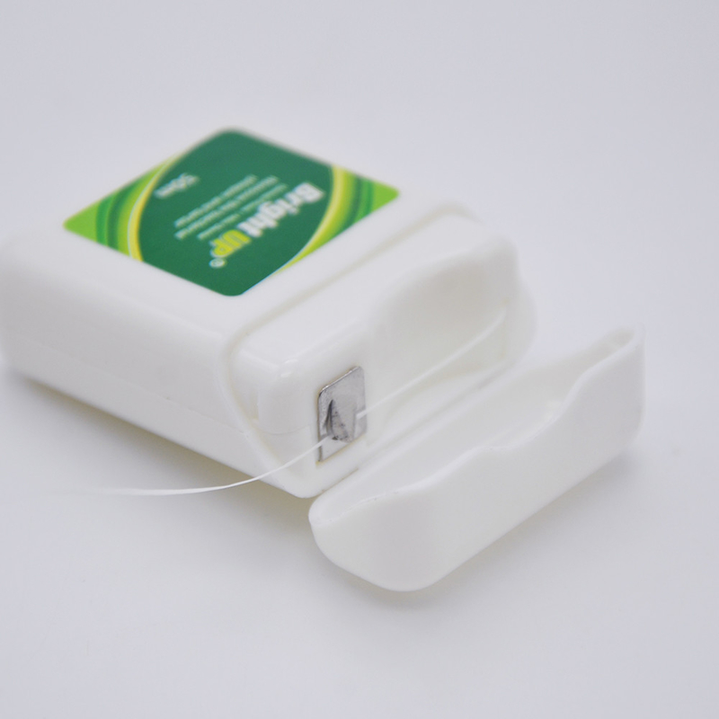 La boîte de fil dentaire ou le fil dentaire biodégradable de fines herbes sélectionnent le soin oral vous gardent sourire